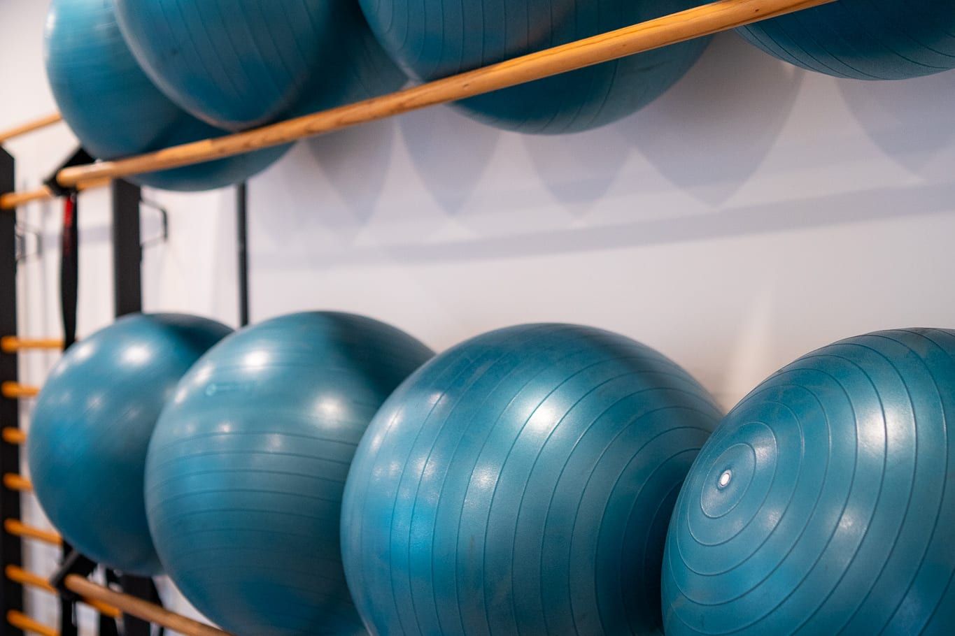 Fitballs colocados en dos barras de madera en la pared de la sala de clases